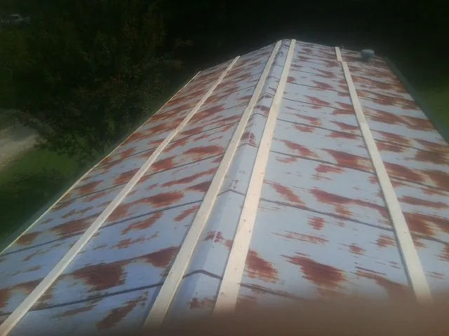Rusted metal roof panels with new wood purlins before replacement — Storm Damage Roof Repair in Coyanosa by Roofing Brothers